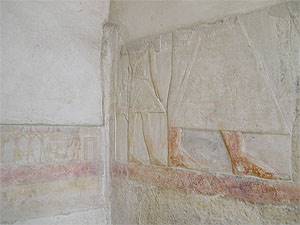 Mastaba de Mereruka (sala de pilares), cementerio de Teti, Saqqara. A la izquierda, un hijo de Mereruka, en el centro Mereruka y, en la esquina derecha en donde puede verse parte de lo que podría ser una figura, estaba esculpido el hijo mayor, cuya figura ha sido totalmente borrada.
